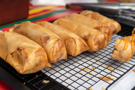 Spring rolls wrap with fried chicken, top with cheese sauce.