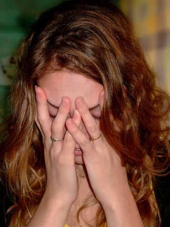 Woman crying and holding his face in his handsの写真素材