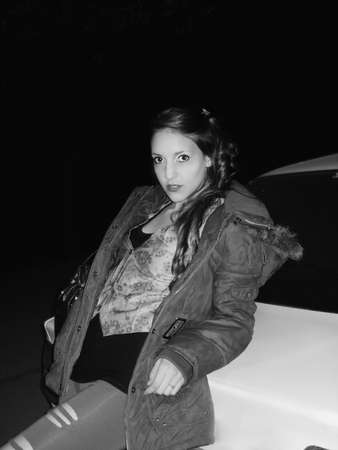 Portrait of a cheerful young female leaning against carの写真素材