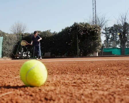 child playing tennis on clay courtの写真素材