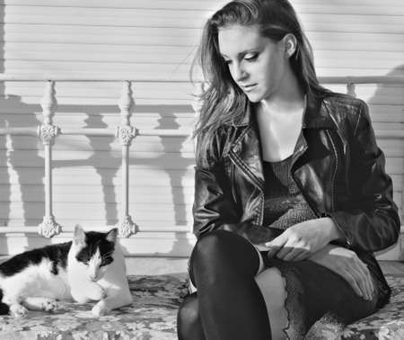 Woman looking lovingly at kitten sitting in a chair ironの写真素材