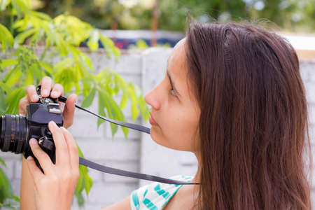 Women taking pictures of the retro camera on nature