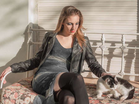 Woman sitting with kitten on the armchairの写真素材