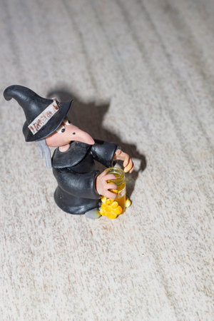 Halloween witch figurine on a wooden background. Selective focus.の写真素材