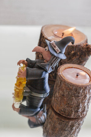 Candle holder with the figure of a witch on a mirror backgroundの写真素材