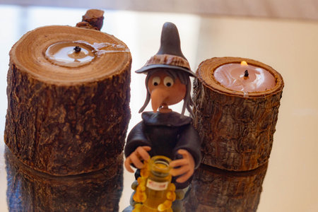 Detail of a candle holder with a miniature witch.