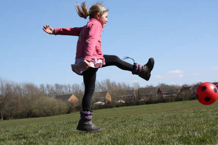 little girl playing footballの写真素材