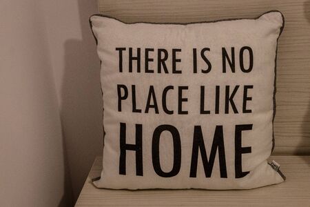 White pillow with "There is no place like home" message written on itの写真素材