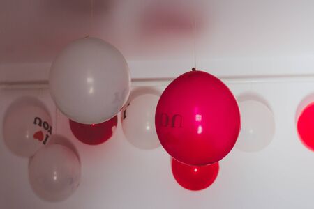 Red and white balloons hanging from the ceilingの写真素材