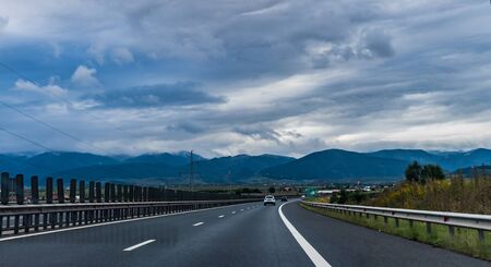 Highway with mountains in the background on an overcast dayの写真素材