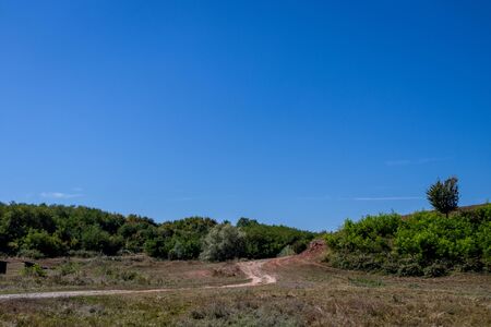 Curvy road crossing a forest covered hillの写真素材