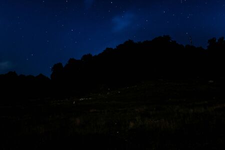 Starry night sky over hills