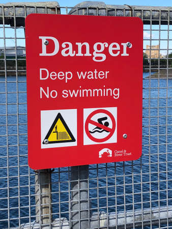 A sign warning people not to swim in deep water, Birkenhead Docks, Wirralの素材