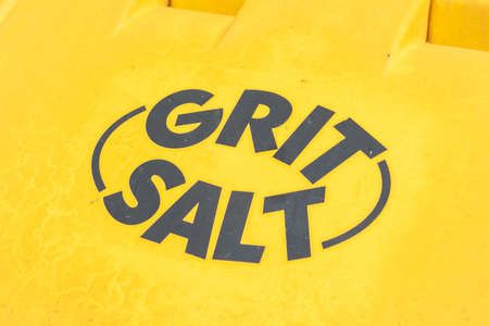 Close up of grit and salt printed on the top of a yellow grit and salt bin Wrexham Wales June 2018の写真素材