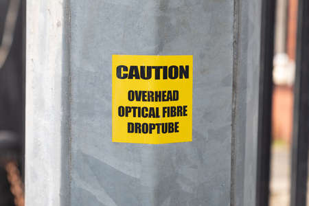 caution sticker on optical fibre pole wallasey wirral August 2019のeditorial素材