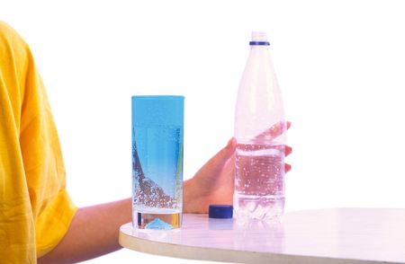 girl in  yellow sports vest holds  bottle with mineral water on  table