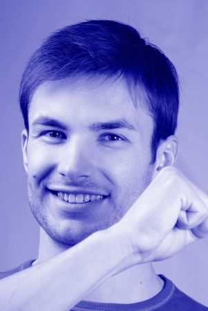 Portrait of  young smiling guy emotionally gesticulating hands, close upの写真素材