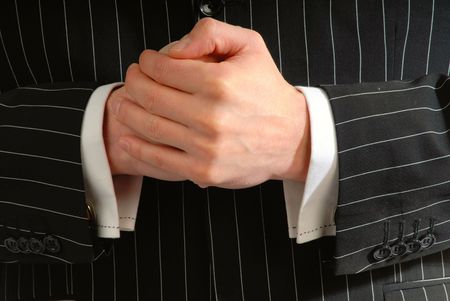 compressed  hands of  businessman on  background of  black jacket, close up