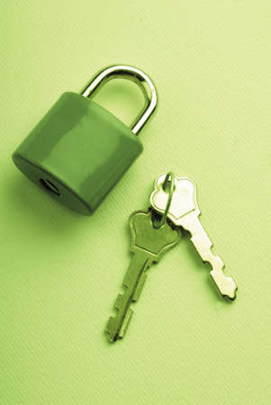 closed lock and separately laying two keys on  green backgroundの写真素材