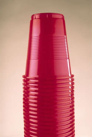 Packing of disposable plastic glasses of red color on  light backgroundの写真素材