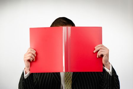 businessman looks  folder of red color with documents on  gray backgroundの写真素材