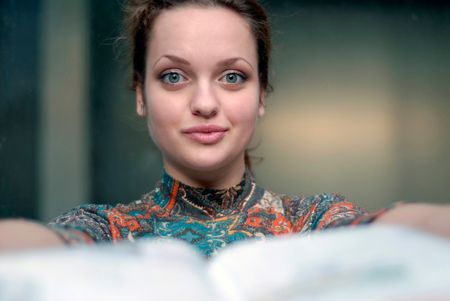 portrait of young woman with opened book in handsの写真素材