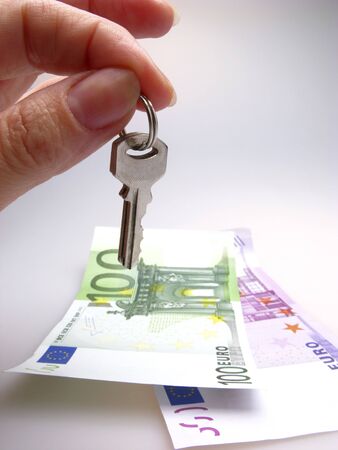 hand with keys above paper denominations of euro,  close upの写真素材