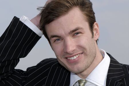 portrait of  young businessman on  background of  skyの写真素材