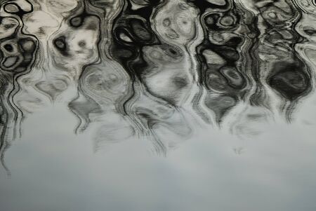 Composition from rhythmical waves on a surface of water of contrast grey color の写真素材