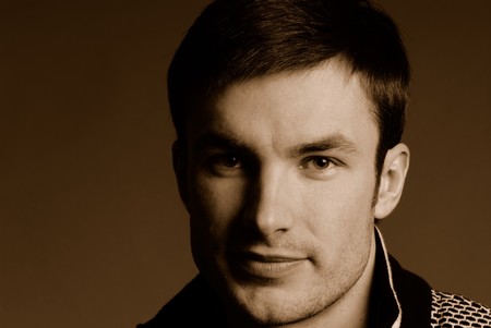 Portrait of  young nice guy in studio on  dark background, close upの写真素材