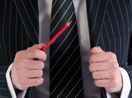 businessman gesticulates with  pencil in  hand on  background of  suitの写真素材