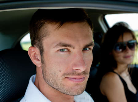 Portrait of the young man against the beautiful woman in the car