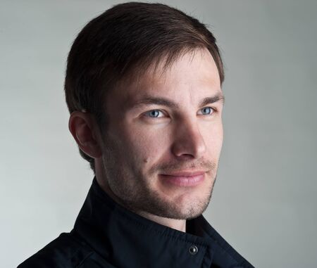 Portrait of the young nice man on a light background, a close up