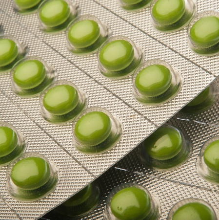 Green medical tablets in vacuum plastic packing