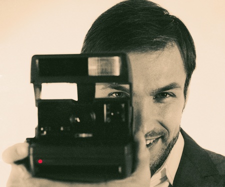 cheerful nice photographer with the camera in hands photographs
