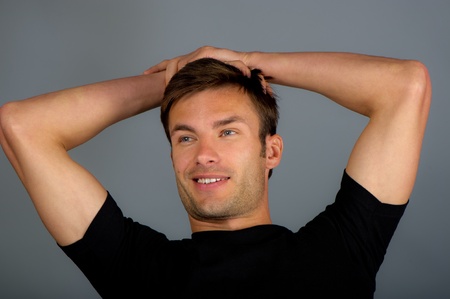 the happy businessman holds hands over the head, on a gray backgroundの写真素材