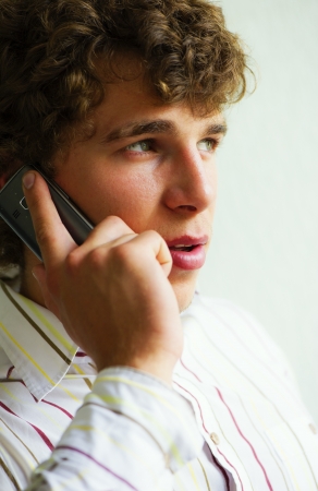 young nice businessman speaks actively by the mobile phoneの写真素材