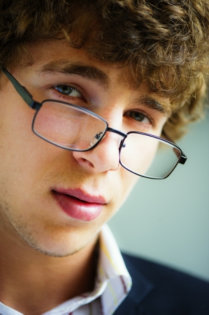 young vigorous businessman works wearing spectacles behind the laptopの写真素材
