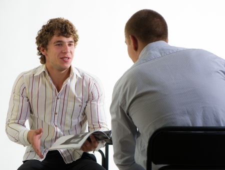 young businessmen offer production according to the catalog on a light backgroundの写真素材