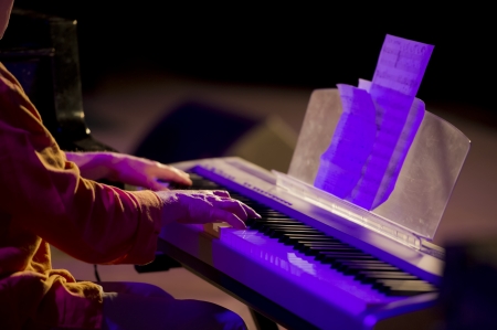 musician playing a keyboard synthesizer during a concertの写真素材
