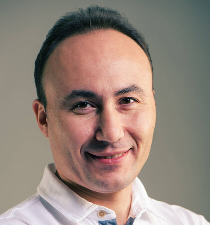 Portrait of a businessman in a shirt looking at the camera and smiling, age thirty-five,...