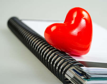 bright red Valentine heart symbol on the background of the day diary, notepadの写真素材