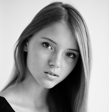 portrait of a beautiful young woman with her hair on a light backgroundの写真素材