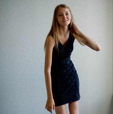 portrait of a beautiful young woman with her hair standing at the wallの写真素材