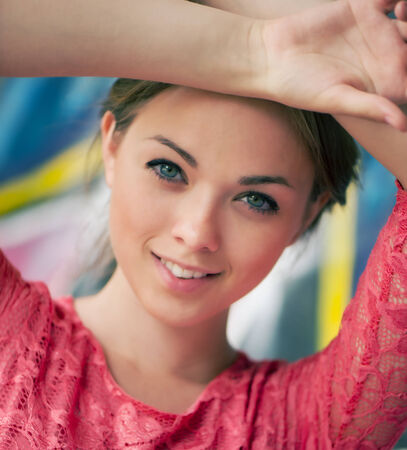 Portrait of a beautiful young girl with hands raised above his head  の写真素材