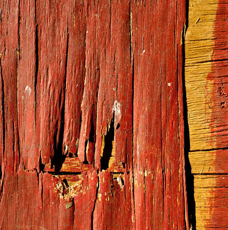 Crumbling wooden surface covered with red paint, lit by sunlight  Closeup の写真素材