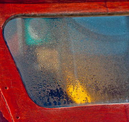 window covered with condensate water motor old boatの写真素材