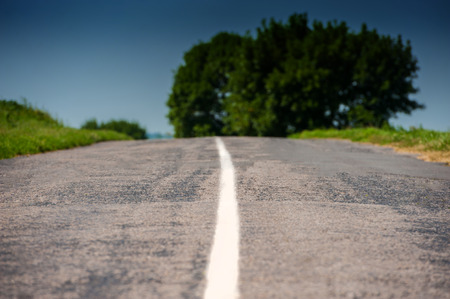 Old asphalt road in the countryside against the skyの写真素材