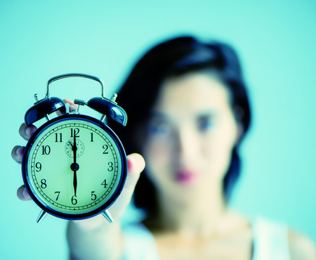 cute asian woman who is holding a clock