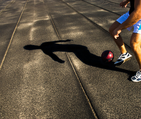 athlete with the ball and shadow on a dark backgroundの写真素材